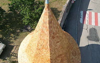 Seitliche Nahaufnahme nach der denkmalgeschützten Dachsanierung einer Turmspitze