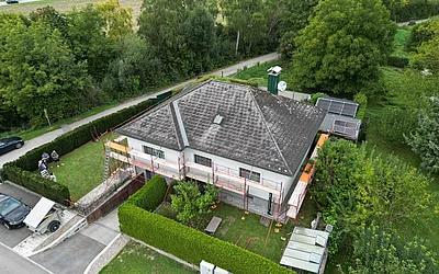 Drohnenaufnahme eines Einfamilienhauses vor der Sanierung seitlich von oben