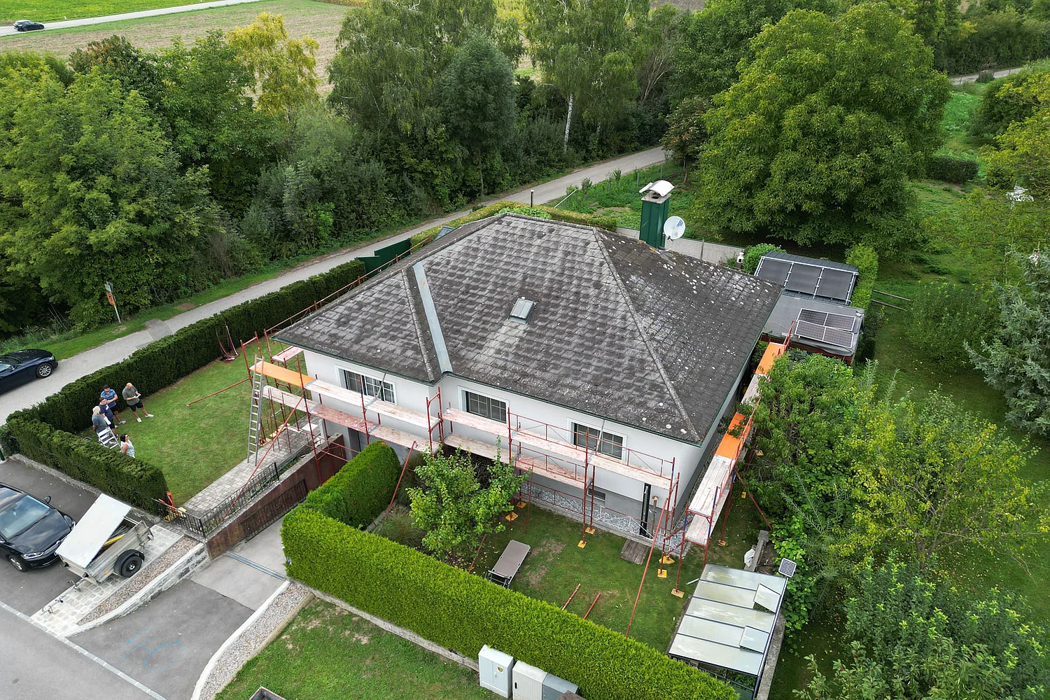 Drohnenaufnahme eines Einfamilienhauses vor der Sanierung seitlich von oben