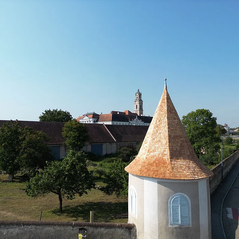 Frontale Drohnenaufnahme nach der denkmalgeschützten Dachsanierung einer Turmspitze