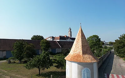 Frontale Drohnenaufnahme nach der denkmalgeschützten Dachsanierung einer Turmspitze