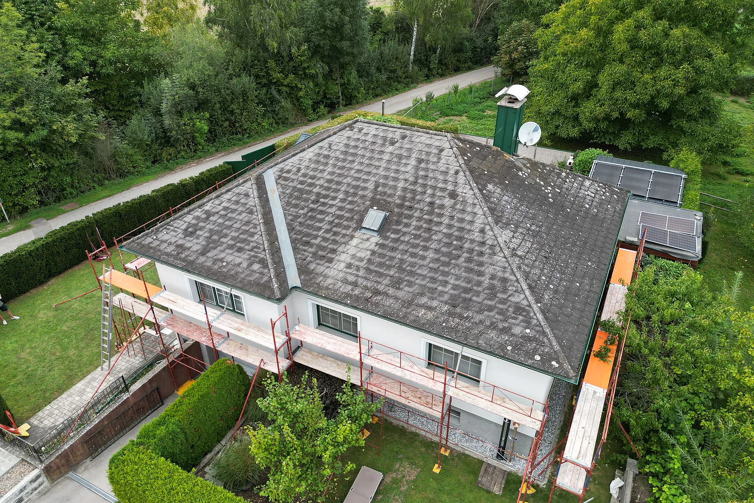 Drohnenaufnahme eines Einfamilienhauses vor der Sanierung seitlich von oben