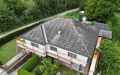 Drohnenaufnahme eines Einfamilienhauses vor der Sanierung seitlich von oben