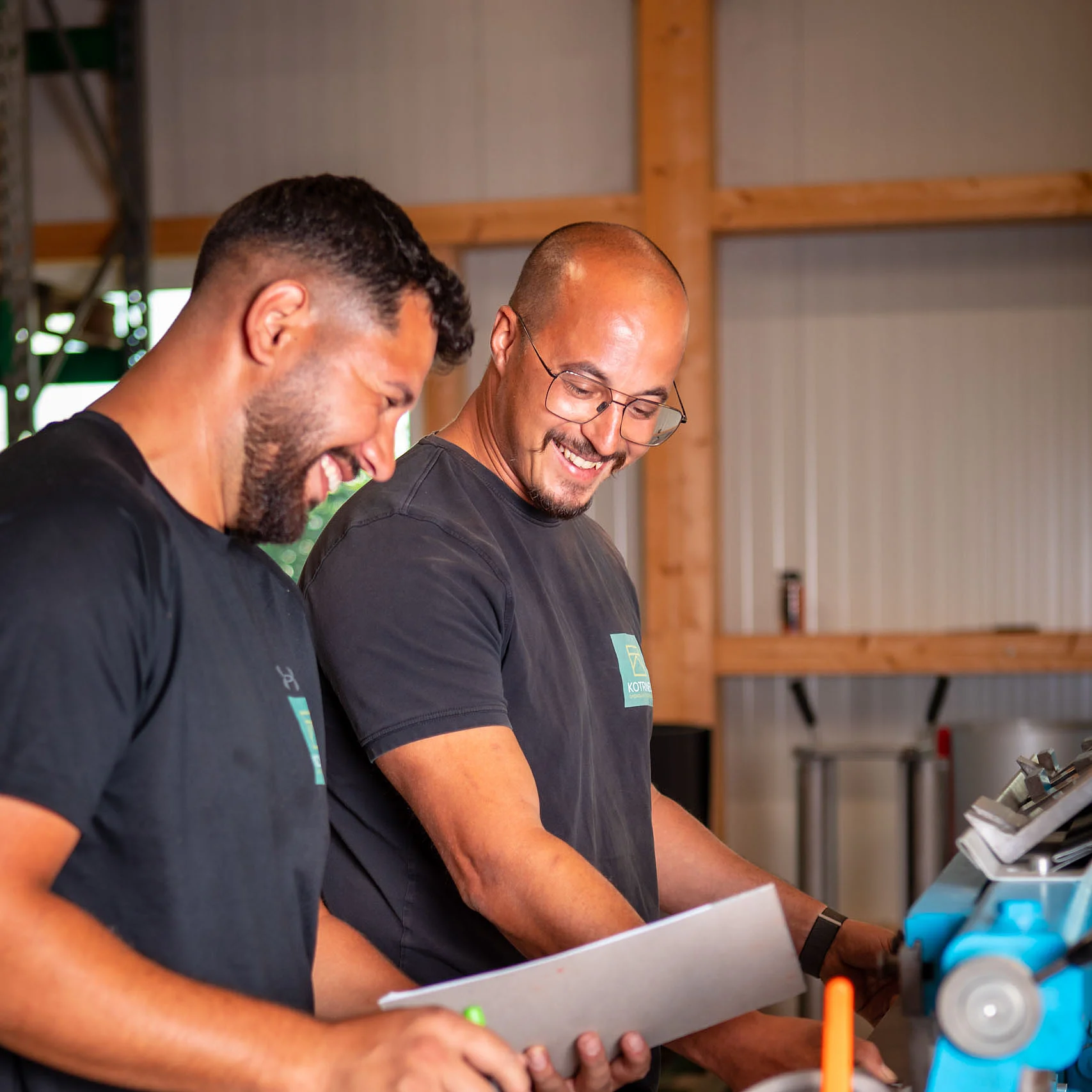 Zwei Mitarbeiter schauen gemeinsam auf einen Block und lachen