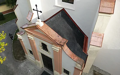 Seitliche Drohnenaufnahme des Eingangsbereichs nach der denkmalgeschützten Dachsanierung