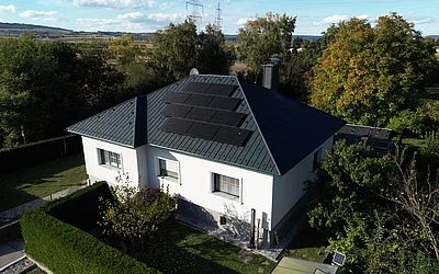 Drohnenaufnahme eines Einfamilienhauses nach der Sanierung seitlich